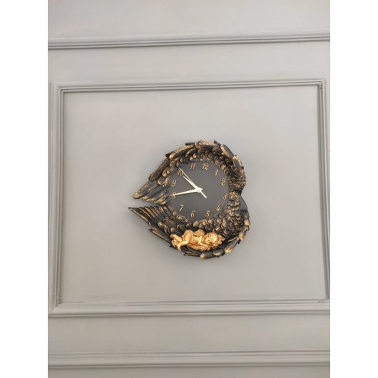 A Decorative Wall Clock In The Form Of Wings In Black And Gold