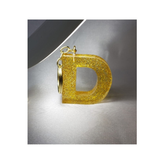 ميدالية مفاتيح من الايبوكسي ذهبية برسم حرف D