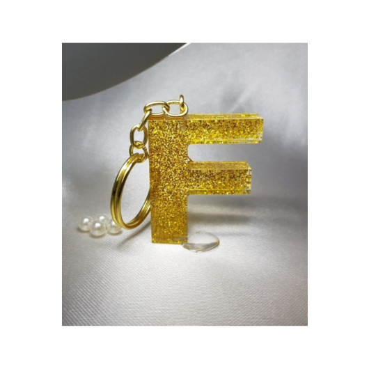 ميدالية مفاتيح ذهبية من الايبوكسي برسم حرف F